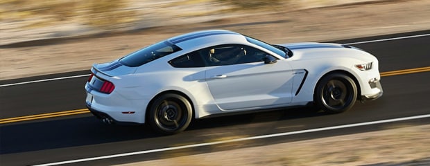 a white ford mustang speeding on a road