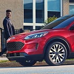 a man looks in awe at the hood of red ford escape 