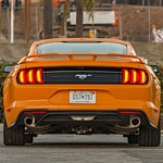 an image of the back of an orange ford mustang 