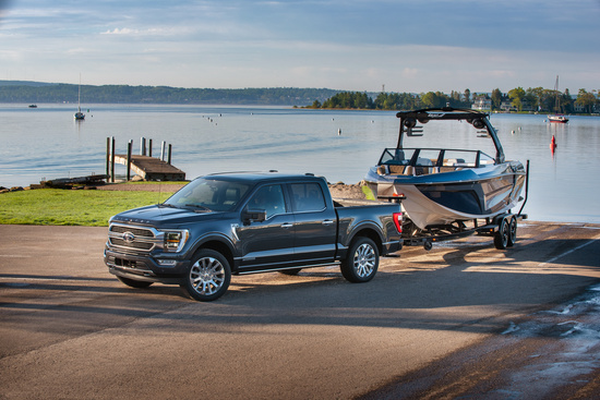 a black truck pulls a boat away from a lake 
