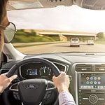 a closeup over the shoulder shot of a man driving a car